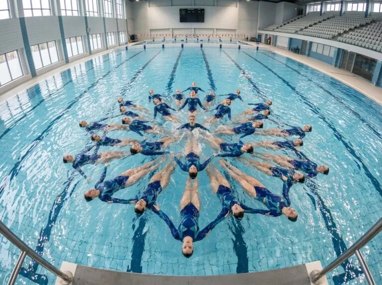 Groupe de nageurs synchronisés en performance dans une piscine
